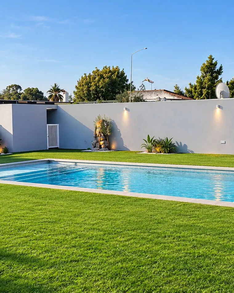 Piscina con el agua cristalina junto al césped en un chalet de El Puerto de Santa María